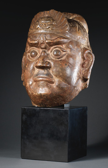 A carved limestone head of a guardian