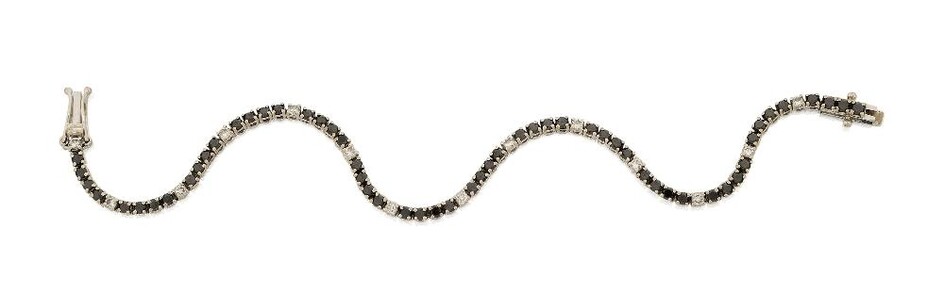 A diamond and black diamond line bracelet, composed of a single row of circular-cut black diamonds interspersed with brilliant-cut diamond spacers, approx. length 18.5cm Please note that the black diamonds have not been tested for natural colour...