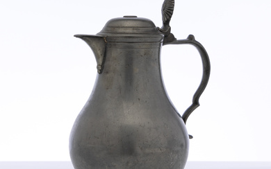 A large antique French pewter lidded jug with fluted shell...