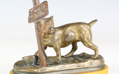 A late 19th century Continental patinated cast bronze model of a dog chained to an inscribed sign po