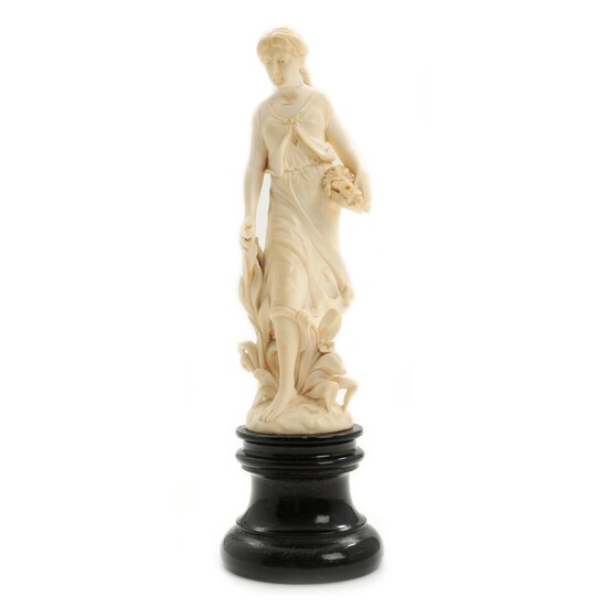 NOT SOLD. A late 19th century carved ivory figurine of Pomona on a black wooden...