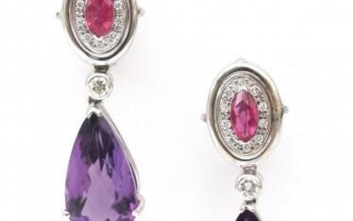 A pair of 18 karat white gold amethyst, ruby and diamond earrings. Featuring a drop faceted cut amethyst suspended by an oval cluster setting with a ruby surrounded by brilliant cut diamonds, ca. 0.30 ct. in total. Gross weight: 13.3 g.