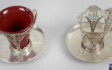 A pair of Art Nouveau silver coffee cup holders & saucers, together with an Edwardian cream jug.