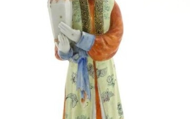 An Oriental porcelain model of a male figure wearing a