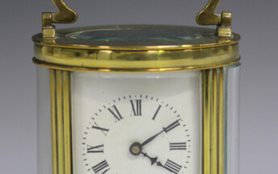 An early 20th century French brass oval cased carriage timepiece with eight day movement, the white