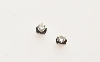 BOUTONS D'OREILLES en or gris 750/°° et diamants taillés en brillant de 0.20 et 0.25 ct environ. PB: 1.1 g.