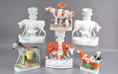 Five Staffordshire flat back cow form spill vases and a donkey