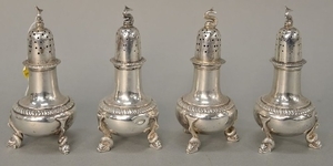 Four sterling silver pepper shakes with dolphin tops.
