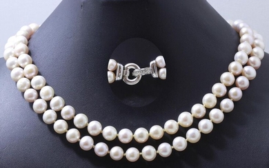 Necklace composed of 2 rows of slightly pinkish freshwater cultured pearls of approximately 8.4 to 9.6 mm. It is embellished with a 750 thousandths white gold pendant making a ratchet clasp punctuated with brilliant diamonds.