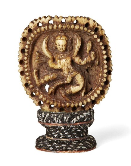 Property of a Gentleman (lots 36-85) A rare Tibetan bone ornament from a necromancer's apron, 16th/17th century, carved with a Buddhist tantric deity inside a beaded and pierced border, 4.5x4cm, silk covered stand