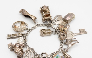 Silver charm bracelet with assorted charms - some articulate...