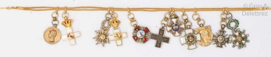 Yellow gold pin and chain holding various yellow gold reductions and argent : seven enamelled decorations, two medals and two war crosses. P. Brut : 17.9g.