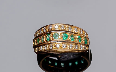 Yellow gold ring with a row of emeralds, flanked...