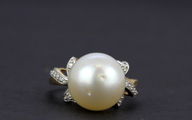 A 10ct yellow gold (marked 10K) ring set with a large cultured pearl and diamond shoulders, (O).