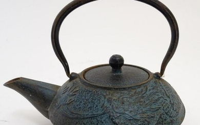 A 20thC Japanese cast iron teapot with swing handle