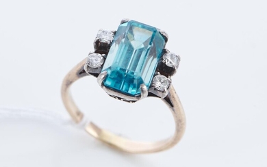 A BLUE ZIRCON AND DIAMOND RING, THE RECTANGULAR CUT ZIRCON ESTIMATED 7.60CTS, IN TWO TONE 14CT GOLD, SIZE O1/2, 5.5GMS