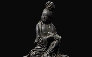 A Chinese finely-carved dark soapstone figure of a seated Guanyin with scroll, 18th century or