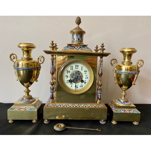 A French brass and enamel clock garniture with enamelled pil...