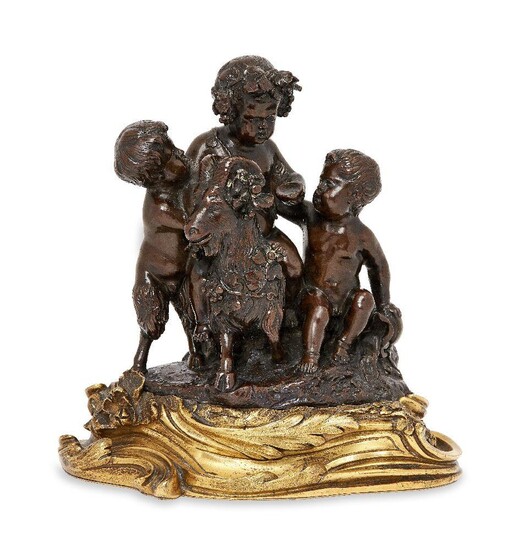 A French bronze group of the infant Bacchus, mid-19th century, depicted seated in a goat flanked by a satyr and boy, on an ormolu rococo style scrolling foliate base, 19cm high, 17cm wide