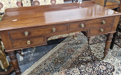 A LATE VICTORIAN MAHOGANY DRESSING TABLE WITH A LOW GALLERIED BACK ABOVE FOUR DRAWERS AND TURNED