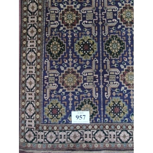 A Persian Tabriz rug. A central repeat pattern on plum groun...