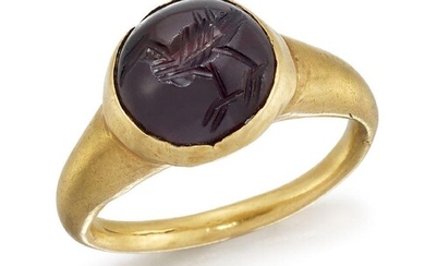 A Sassanian gold and garnet finger ring, the cabochon garnet seal stone engraved with a bird to a gold rub-over setting and tapering hoop, c. 6th century AD, ring size I From a private collection acquired prior to 1990