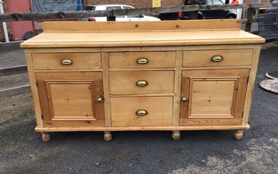 A Victorian pine dresser with rectangular moulded top having three...