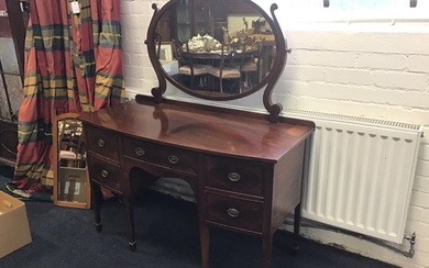 A bowfronted late Victorian mahogany dressing table with oval mirror...