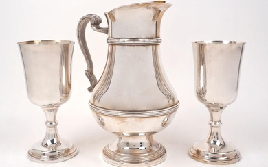 A large silver plated water jug, by Christofle, post 1983, the reeded baluster body with gilded interior to textured scroll handle, the pouring lip with ice trap, 27.5cm high, together with two silver plated Communion cups, one with engraving dated...
