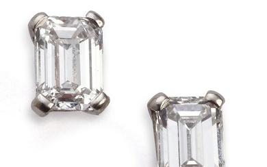 A pair of diamond ear studs each set with an emerald-cut diamond...