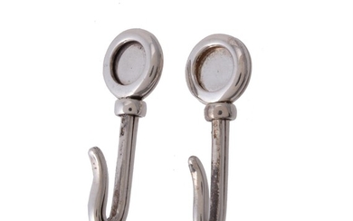 A pair of silver napkin hooks