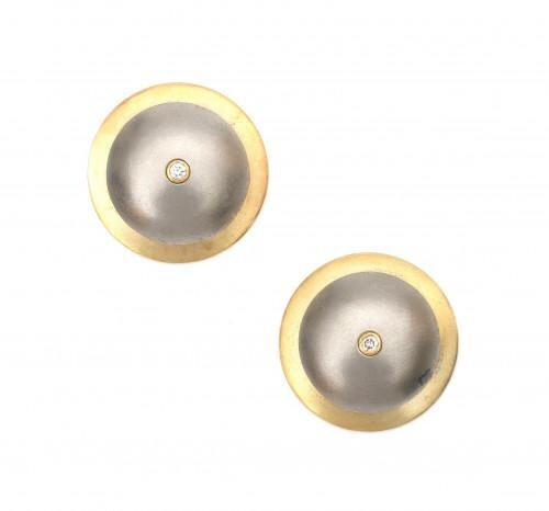 A pair of two tone diamond disc shaped ear studs. Of dome shaped design with a yellow gold rim and a grey white gold center. Each earring features a brilliant cut diamond of ca. 0.04 ct., making 0.08 ct. in total, ca. G-H, ca. VS. Found below the...