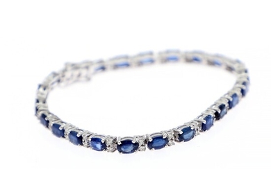 A sapphire and diamond bracelet set with numerous oval-cut saphhires flanked by diamonds, mounted in 14k white gold. L. app. 18.5 cm.