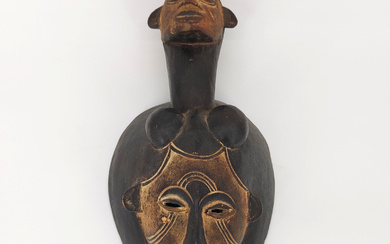 AFRICAN ELEGANCE: TRADITION AND AESTHETICS IN A WOODEN WALL MASK.