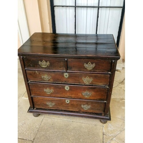 AN EARLY 18TH CENTURY OAK CHEST OF DRAWERS Having a plank to...
