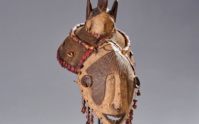 [ART AFRICAIN] Nigeria. Masque IGBO en bois sculpté, toile, cauris et verroteries. H: 40 cm.