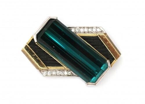 An 18 carat gold two tone tourmaline and diamond pendant. Featuring a dark green emerald cut tourmaline surrounded with fourteen brilliant cut diamonds, ca. 0.20 ct. in total. Gross weight: 15.8 g.