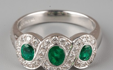 An 18ct white gold emerald and diamond ring, set with three ...