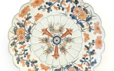 An Oriental plate with a scalloped rim decorated in the