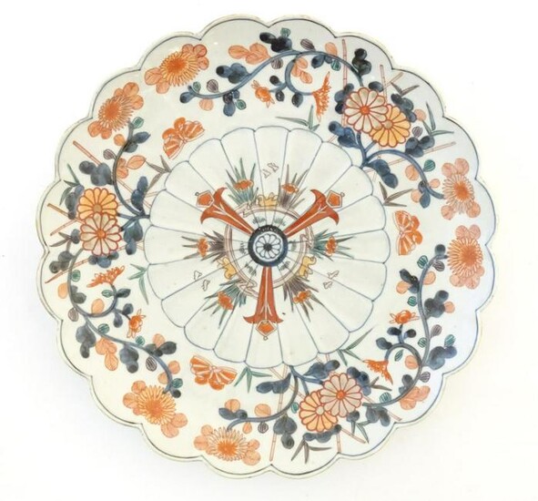 An Oriental plate with a scalloped rim decorated in the