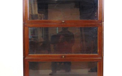 An early 20th century walnut sectional bookcase, comprising of plinth,...