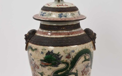 Chinese famille verte crackle glazed vase and cover, circa 1900, decorated with dragons chasing a flaming pearl, mask handles and foo dog knop, four-character mark to base, with carved wooden stand...