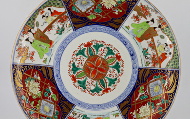 Grande piatto in porcellana policroma decorato con personaggi e fiori Giappone, XX (d cm 39,5)
