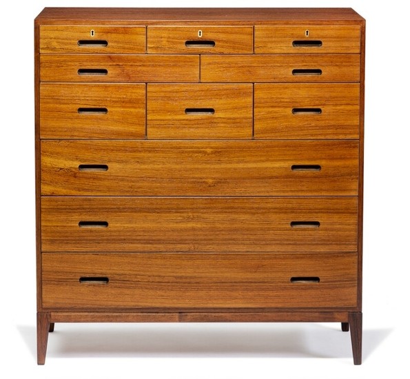 Kaj Winding: Rosewood chest of drawers mounted on tapering legs. Front with 11 drawers in various sizes, carved handles and brass key holes.