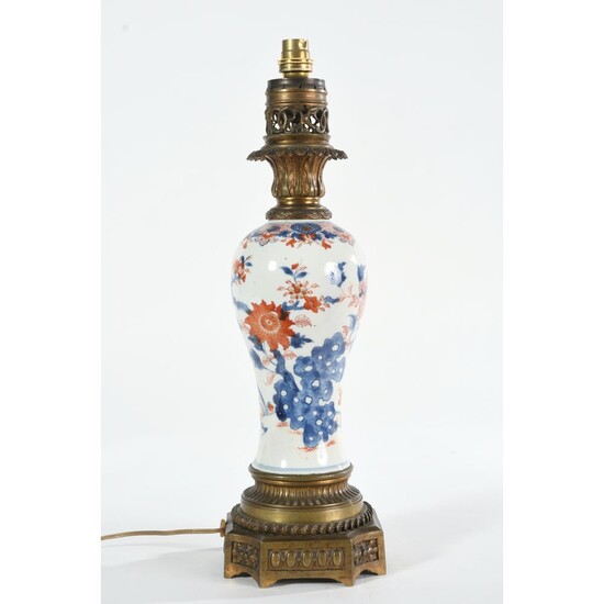 LAMPE en porcelaine d’IMARI à décor de grosses fleurs en bleu et rouge. (1 fêle)....