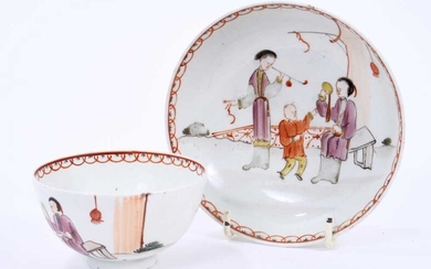 Lowestoft tea bowl and saucer, painted in the Mandarin style with three figures, one smoking a pipe, within a red overlapping loop border, saucer 12.1cm diameter