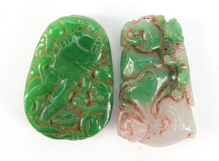 Two Chinese carved green jade pendants, the largest