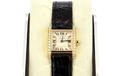 A Cartier marked 18k yellow gold wristwatch (no. MG260564) with a diamond set bezel on an embossed black leather strap with marked 18k gold