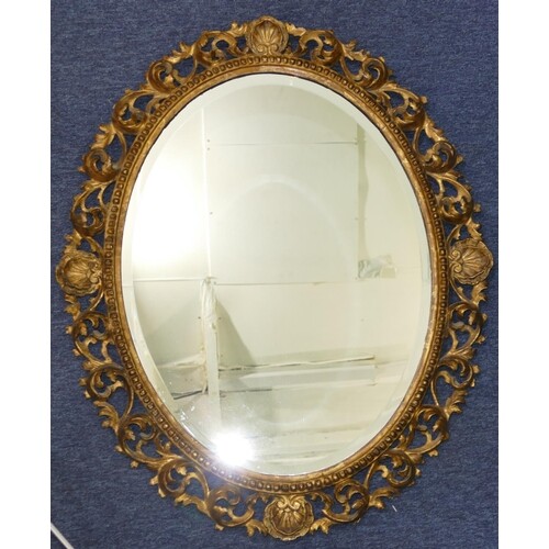 A Carved Giltwood Oval Bevelled Hanging Wall Mirror with rai...