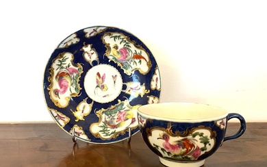 A Dr Wall Worcester Porcelain Cup and Saucer, Blue Ground with Vignettes Decorated with Exotic Birds, Gilt Highlights, Fret Mark to Base